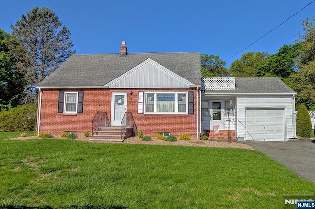 view of front of home with a garage, a chimney, a front lawn, and aphalt driveway