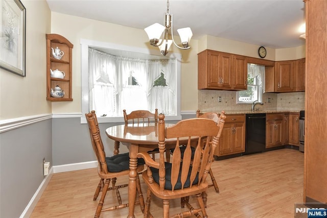 dining area featuring baseboards, light wood-style flooring, and a notable chandelier