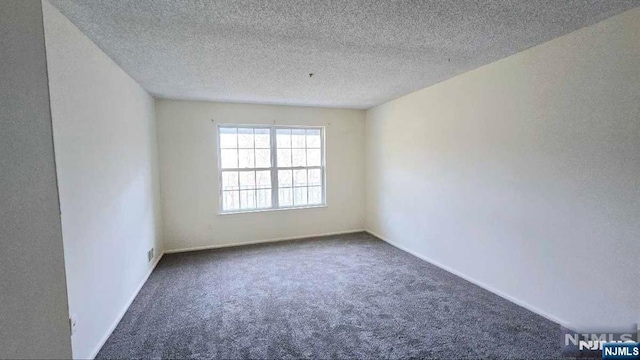 carpeted spare room with baseboards and a textured ceiling