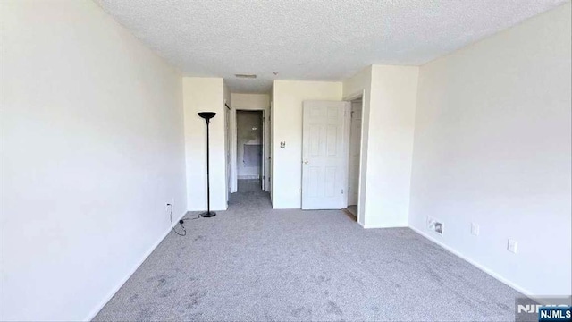 unfurnished bedroom featuring carpet flooring, a textured ceiling, and baseboards