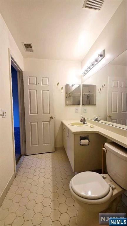 bathroom with toilet, baseboards, visible vents, and vanity