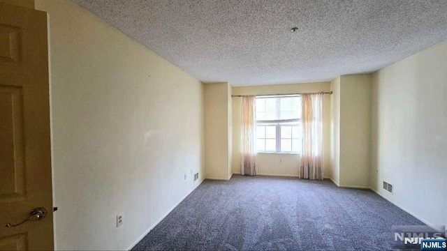 carpeted empty room with a textured ceiling and visible vents