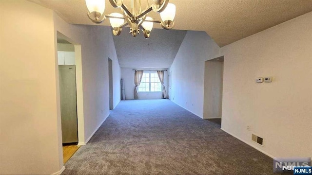 hallway with carpet floors, a textured ceiling, an inviting chandelier, and visible vents