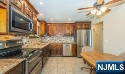 kitchen featuring ceiling fan, appliances with stainless steel finishes, tasteful backsplash, light tile patterned floors, and recessed lighting