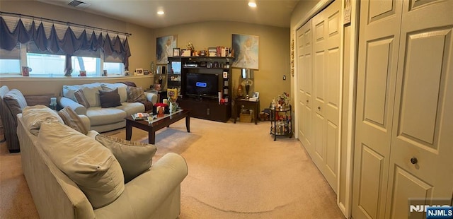 living area with visible vents, recessed lighting, and light carpet