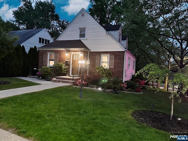 view of front of house with brick siding and a front lawn