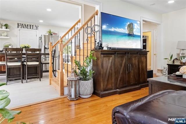 living area with wood finished floors, stairway, and recessed lighting