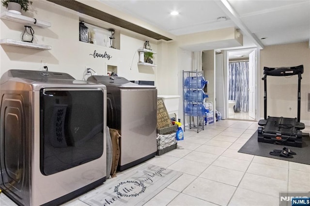 clothes washing area with independent washer and dryer and light tile patterned floors