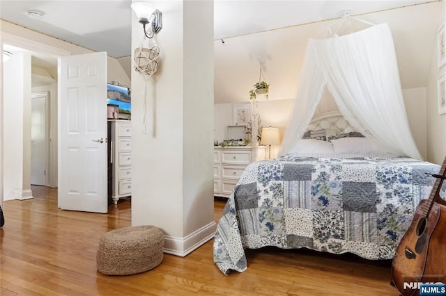 bedroom with wood finished floors and baseboards