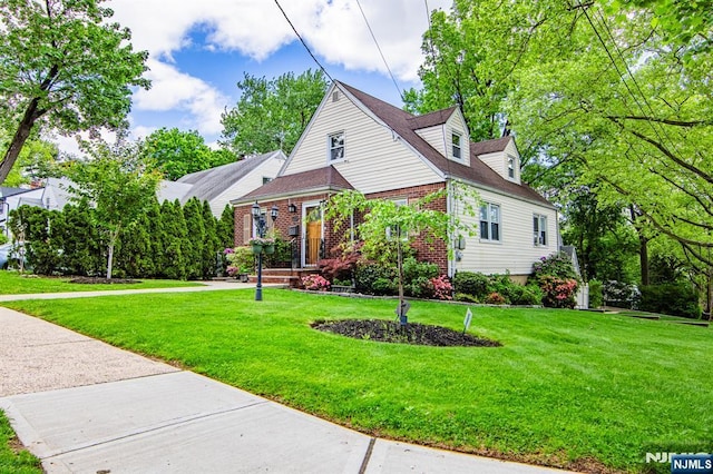 view of front facade featuring brick siding and a front yard