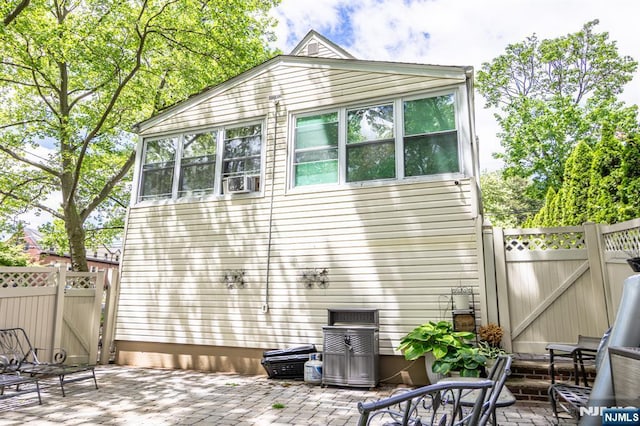 back of property featuring a patio area, a gate, and fence