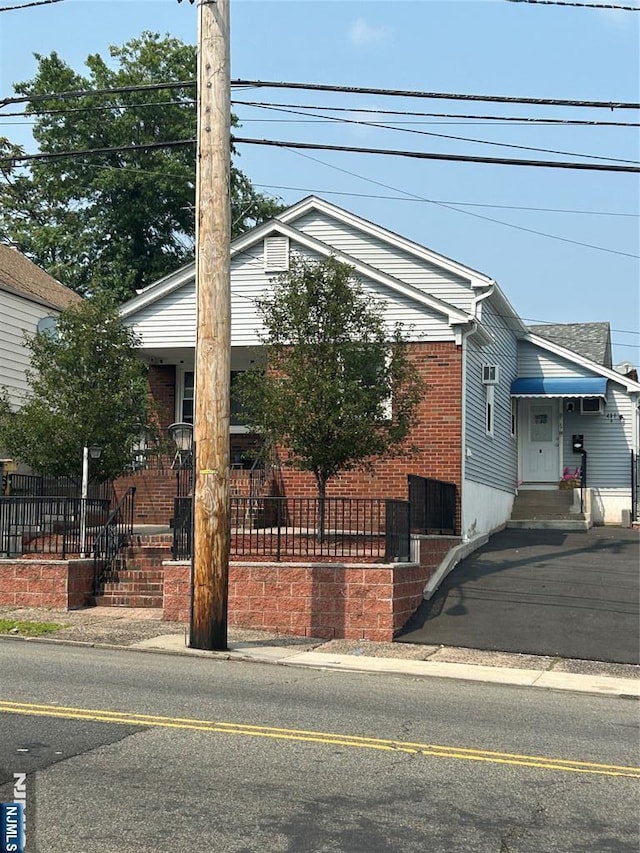view of front of house with brick siding and fence