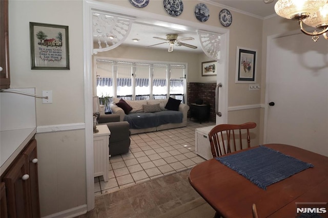 dining area with ornamental molding and ceiling fan with notable chandelier