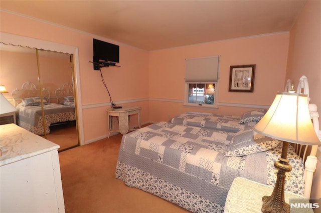 bedroom with baseboards, light colored carpet, ornamental molding, and a closet