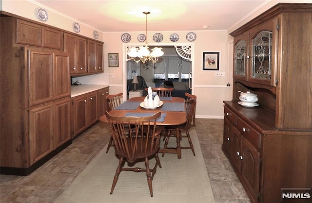 dining room with baseboards, an inviting chandelier, and ornamental molding
