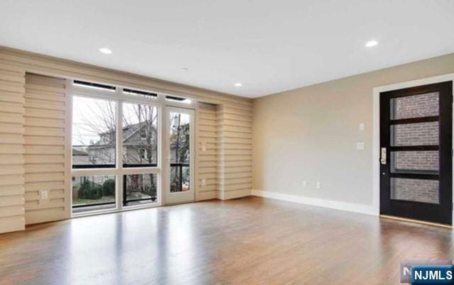 interior space featuring baseboards, recessed lighting, and wood finished floors