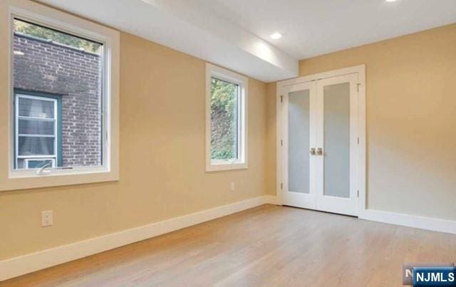 unfurnished room featuring recessed lighting, baseboards, french doors, and wood finished floors