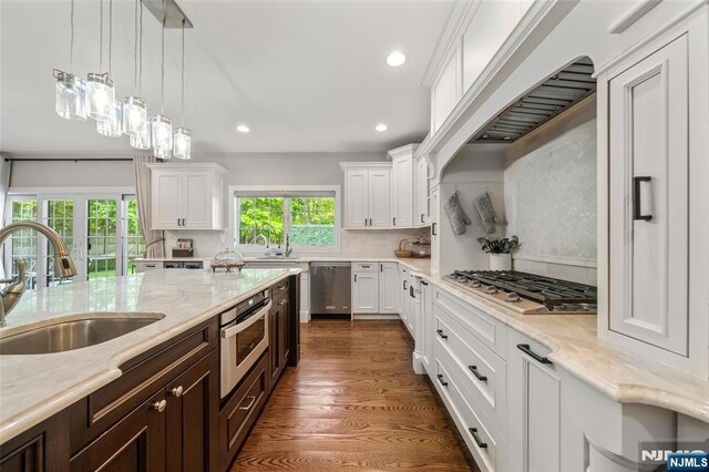 kitchen with a sink, appliances with stainless steel finishes, white cabinetry, recessed lighting, and backsplash