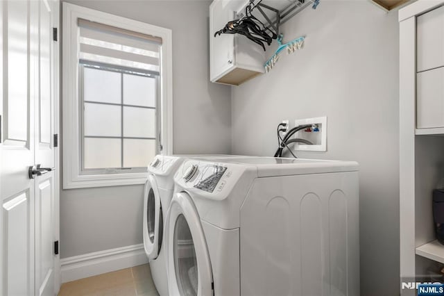 washroom featuring cabinet space, washer and dryer, and baseboards