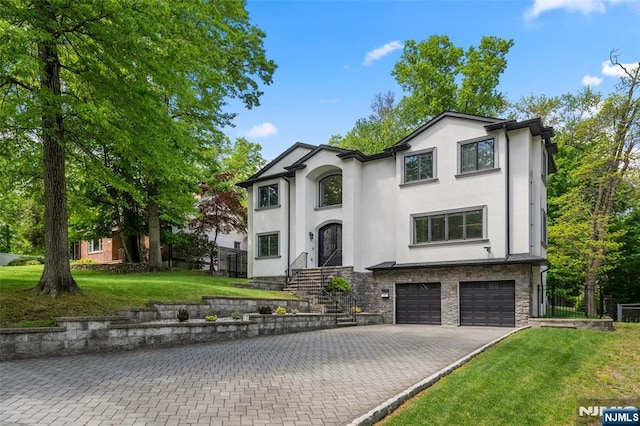 view of front of house featuring stucco siding, an attached garage, asphalt driveway, and stone siding