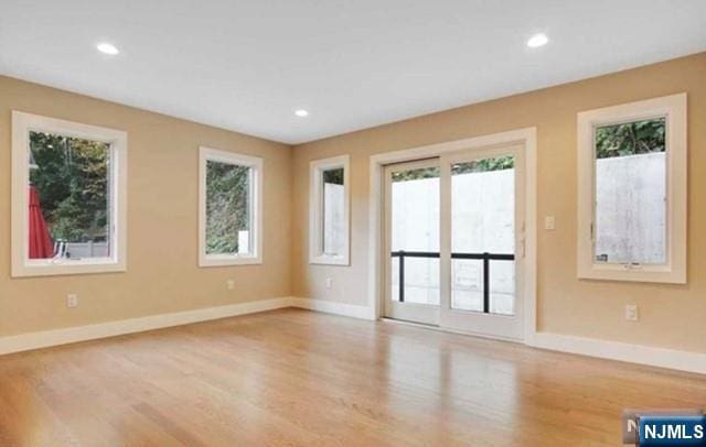 unfurnished living room featuring recessed lighting, baseboards, and wood finished floors