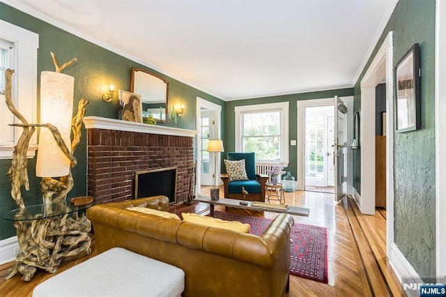 living area featuring baseboards, ornamental molding, a brick fireplace, and wood finished floors