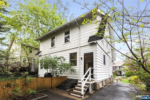 view of front facade featuring fence and entry steps