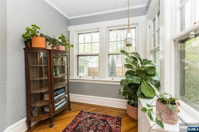 sitting room featuring crown molding, baseboards, a textured wall, and wood finished floors