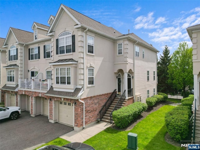 202 Blue Heron Dr, Secaucus, NJ 07094 - view of property featuring aphalt driveway, a front yard, stucco siding, brick siding, and an attached garage