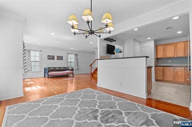 202 Blue Heron Dr, Secaucus, NJ 07094 - interior space featuring visible vents, open floor plan, an inviting chandelier, ornamental molding, and light wood-style flooring
