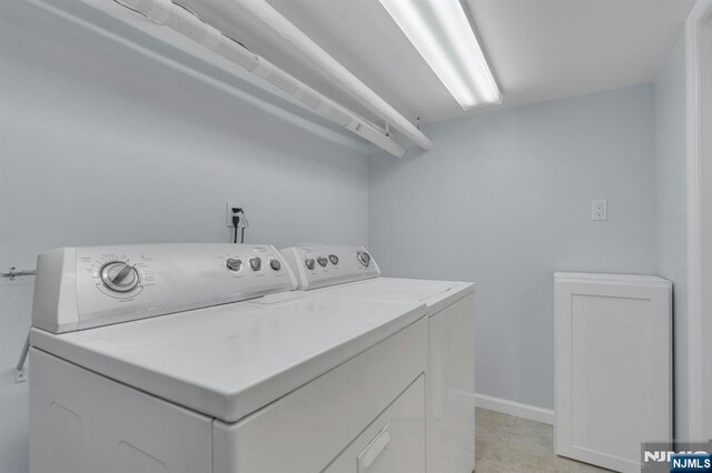 clothes washing area featuring laundry area, baseboards, and independent washer and dryer
