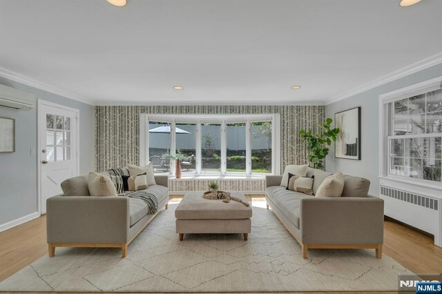 living area featuring a wealth of natural light, ornamental molding, and radiator heating unit