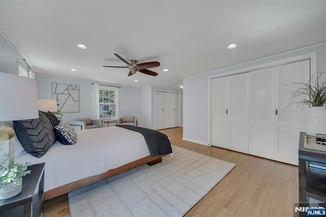 bedroom featuring ceiling fan, multiple closets, recessed lighting, and wood finished floors