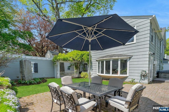 back of property featuring a lawn, a patio, and outdoor dining area