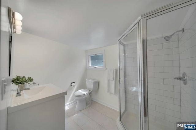 full bathroom with toilet, baseboards, vanity, and a stall shower