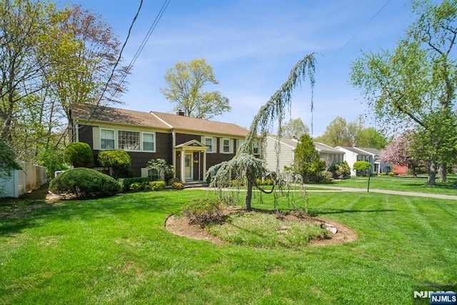 bi-level home featuring a chimney and a front yard