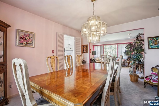carpeted dining space featuring a chandelier
