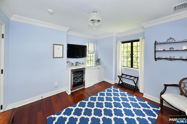 sitting room featuring crown molding, baseboards, dark wood-style floors, and visible vents