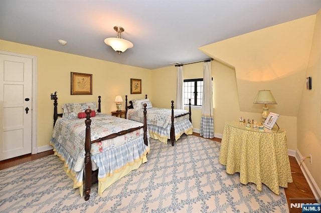 bedroom featuring baseboards and wood finished floors