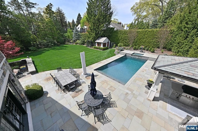 view of swimming pool featuring a yard, outdoor dining area, an outdoor structure, and a patio area