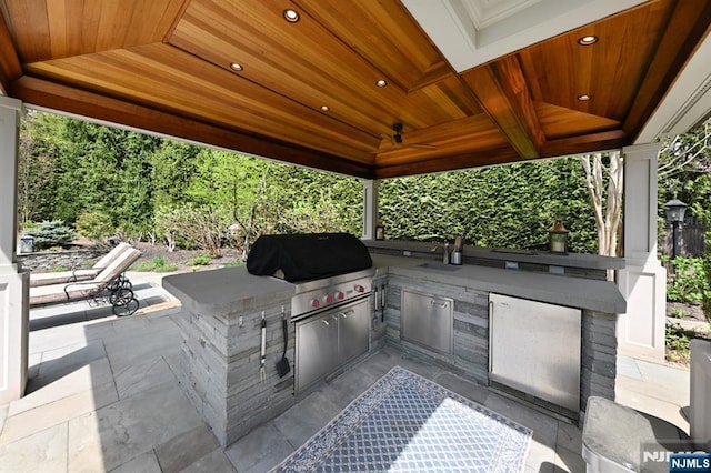 view of patio / terrace with a sink, a gazebo, area for grilling, and a grill