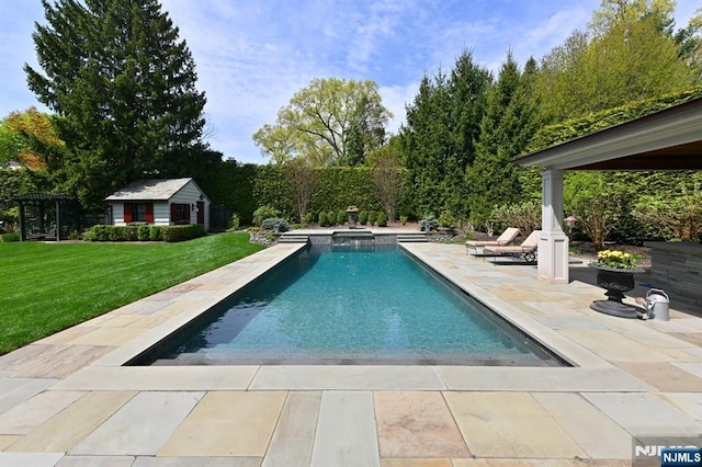 pool with a patio, an outbuilding, a storage structure, and a yard