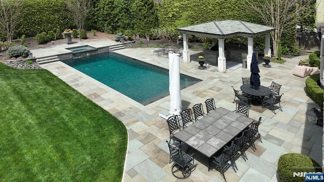 view of swimming pool featuring a lawn, a patio, a gazebo, a pool with connected hot tub, and outdoor dining space