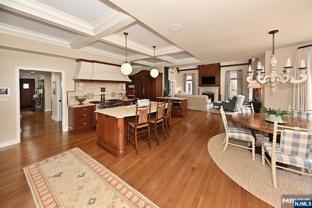 kitchen featuring a kitchen bar, light countertops, custom exhaust hood, dark wood-style floors, and open floor plan
