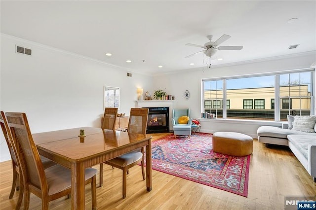 99 Park Ave Unit 5D, Hoboken, NJ 07030 - dining area featuring a ceiling fan, visible vents, a glass covered fireplace, and light wood-style flooring