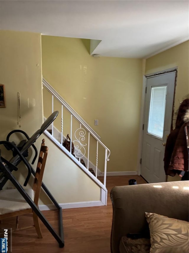 stairs with wood finished floors and baseboards