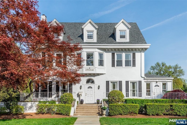 view of front of property featuring a shingled roof