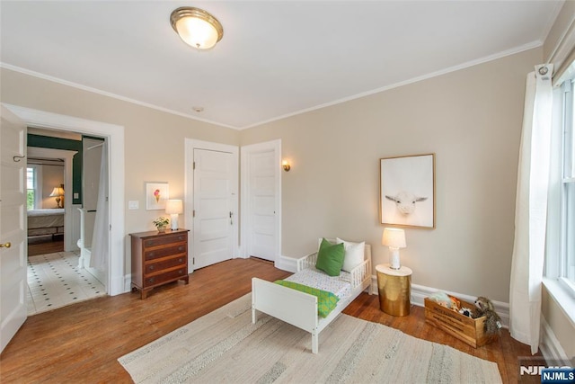 bedroom featuring ornamental molding, baseboards, and wood finished floors