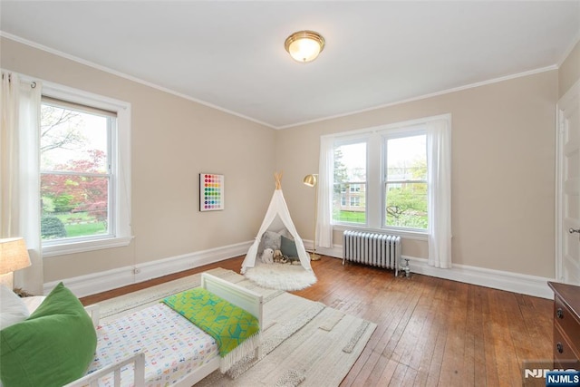 playroom with baseboards, plenty of natural light, and radiator heating unit