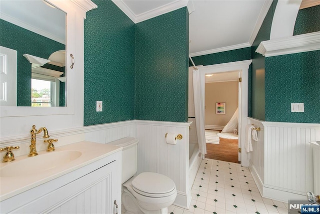 bathroom featuring a wainscoted wall, toilet, vanity, and ornamental molding